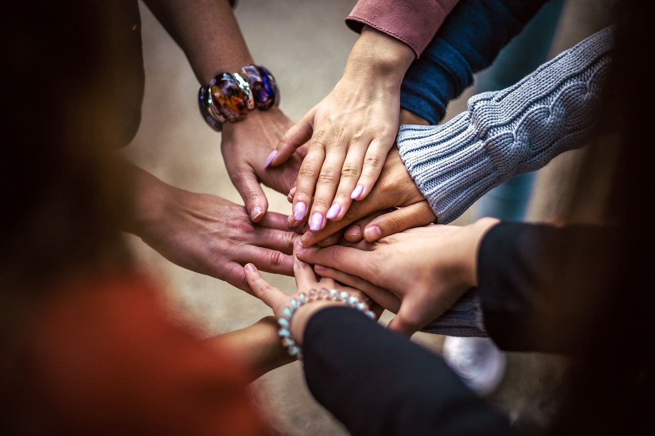 People joining hands in teamwork and community