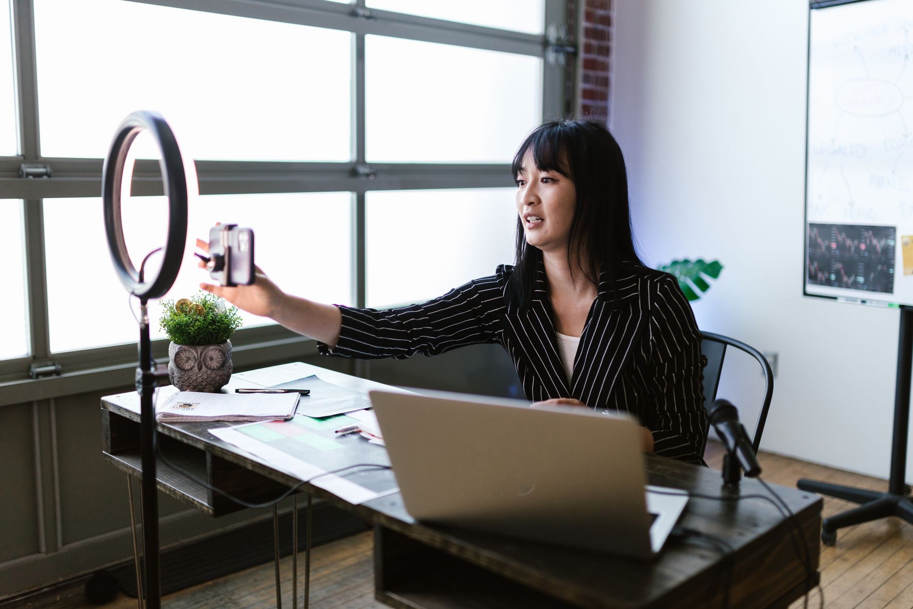 Creator using a ring light and camera at a desk setup