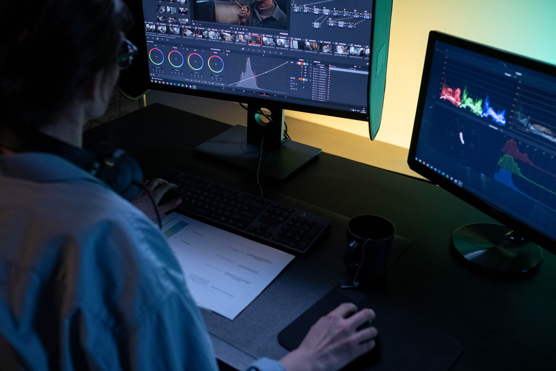 Creator editing video on a dual-monitor computer setup