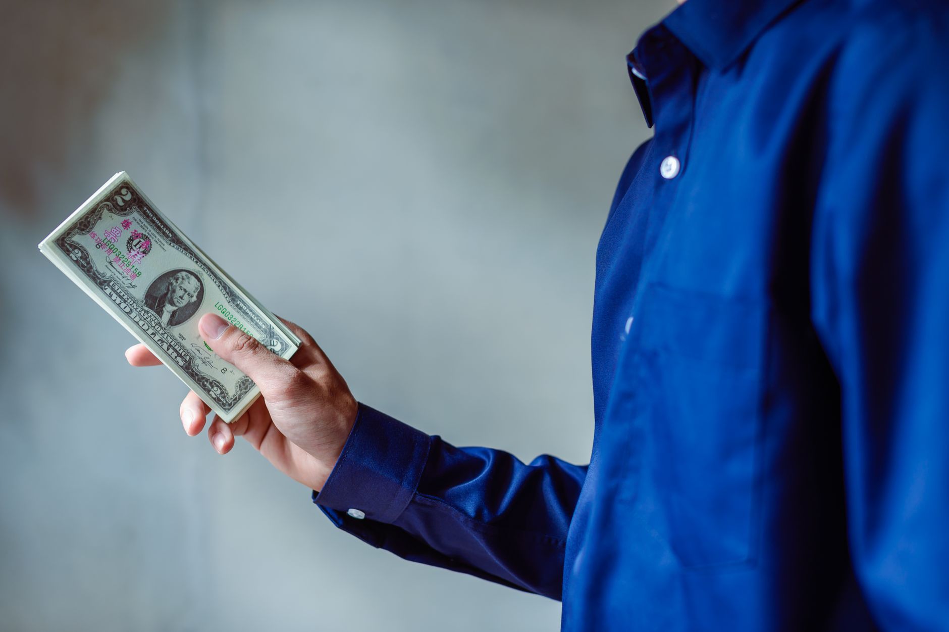 Person holding US dollar bills representing YouTuber salary and creator income