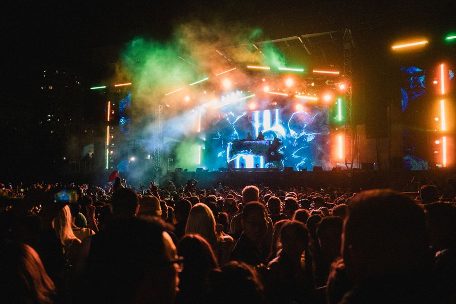 A concert stage lit with neon lights above a crowd